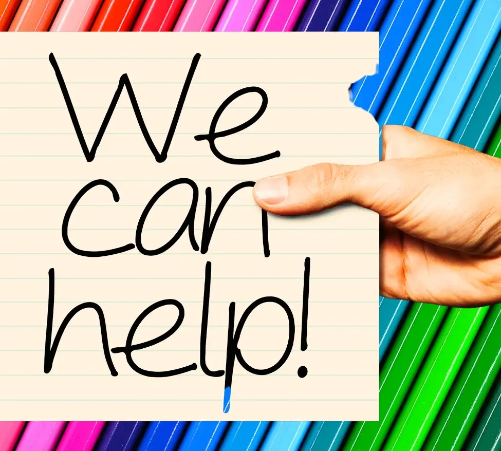 Picture is a close up of coloured pencils with a post it note on top saying We Can Help! Picture sits within a contact us form.